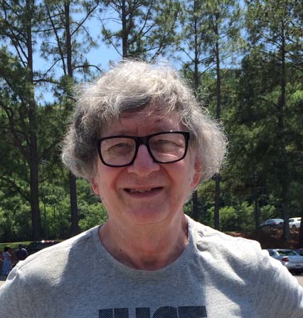 An older man wearing glasses and a t - shirt.