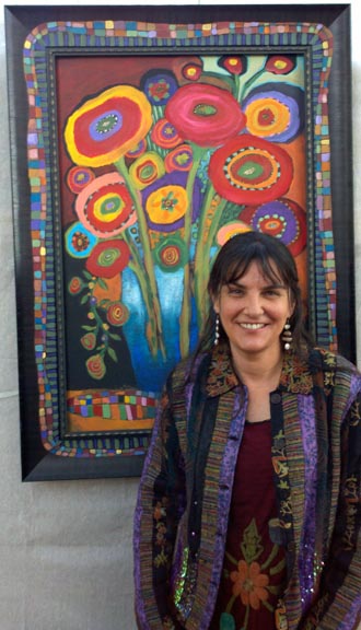A woman standing in front of a colorful painting.