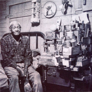 A man sitting in front of a pile of boxes.