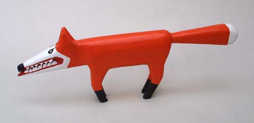 A wooden toy fox with a black mouth.