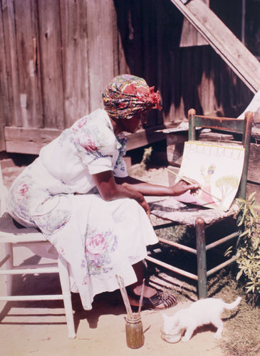 A woman sitting in a chair with a cat.