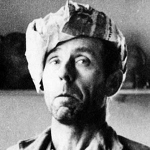 A black and white photo of a man wearing a hat.