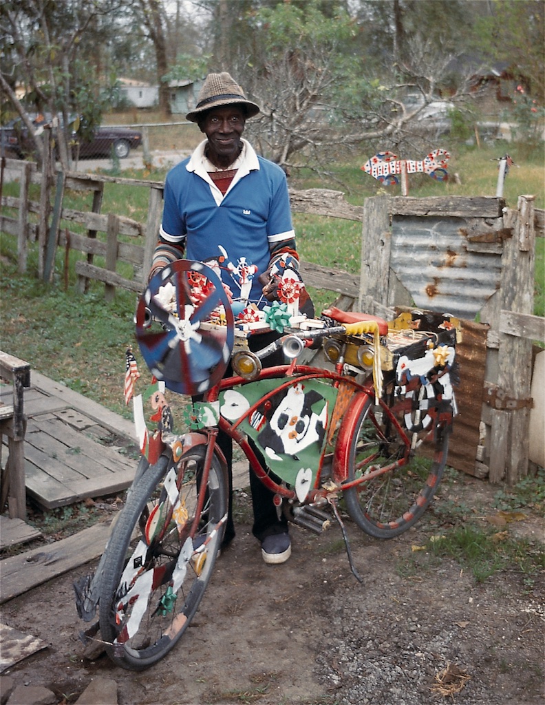 A man standing next to a decorated bicycle.