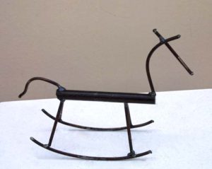 A small metal sculpture of a rocking horse