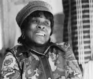 A black and white photo of a woman wearing a hat.