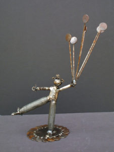 A small metal sculpture of a clown holding balloons