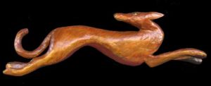 Wood sculpture of a leaping dog