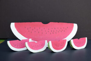 Watermelons dated 1986 by Ned Cartledge (1 large, 4 small) 	acrylic on shaped wood 	4.5" x 13.5" x 4" large 1.75" x 4" x 1" small 	 	$500 #13094
