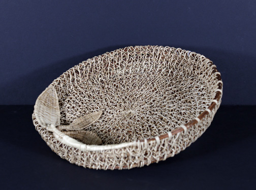 A small woven basket with a leaf on it.