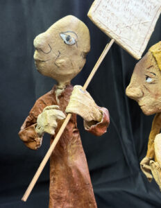 detail brown figure "Three Wisemen--Fools"  c. 1991 by Hope Atkinson  (3 figures with two signs)papier mache & paint with found metal spring  tallest figure 7"  $1400  #13734