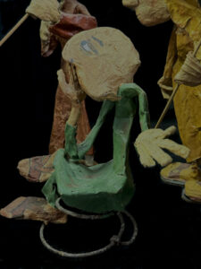 detail green figure "Three Wisemen--Fools"  c. 1991 by Hope Atkinson  (3 figures with two signs)papier mache & paint with found metal spring  tallest figure 7"  $1400  #13734